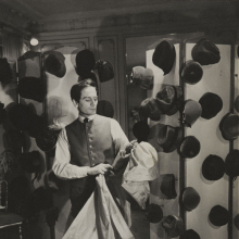 Pierre Cardin in his couture salon, holding a bolt of fabric