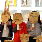 Kids holding masks they've made