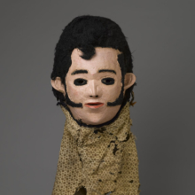 <p><em>“Elvis” Mask for Nyau Society</em>, circa 1977. Unidentified Chewa artist. Central or Southern Region, Malawi, Africa. Wood, paint, fiber, cloth, 11 × 9<sup>1</sup>⁄<sub>2</sub> x 7<sup>1</sup>⁄<sub>4</sub> in. (27.9 × 24.1 × 18.4 cm). Brooklyn Museum; Gift of Mr. and Mrs. J. Gordon Douglas III, Frederick E. Ossorio, and Elliot Picket, by exchange, and Designated Purchase Fund, 2010.41. (Photo: Sarah DeSantis, Brooklyn Museum) 2011.4.2</p>