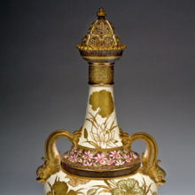 <p>Edward Lycett (American, b. England, 1833–1910). Faience Manufacturing Company (1881–92). <i>Covered Vase</i>, 1889. Cream-colored earthenware with ivory glazed ground painted with polychrome enamels; flat and raised gold paste decoration. The Henry Ford, Dearborn, Michigan, 60.135</p>