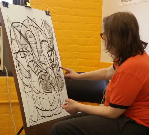 An artist drawing with charcoal