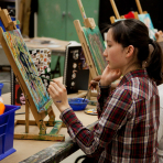 A teen paints in a Gallery/Studio art class