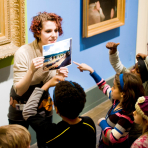 Children and a teacher looking at art in the Brooklyn Museum galleries.