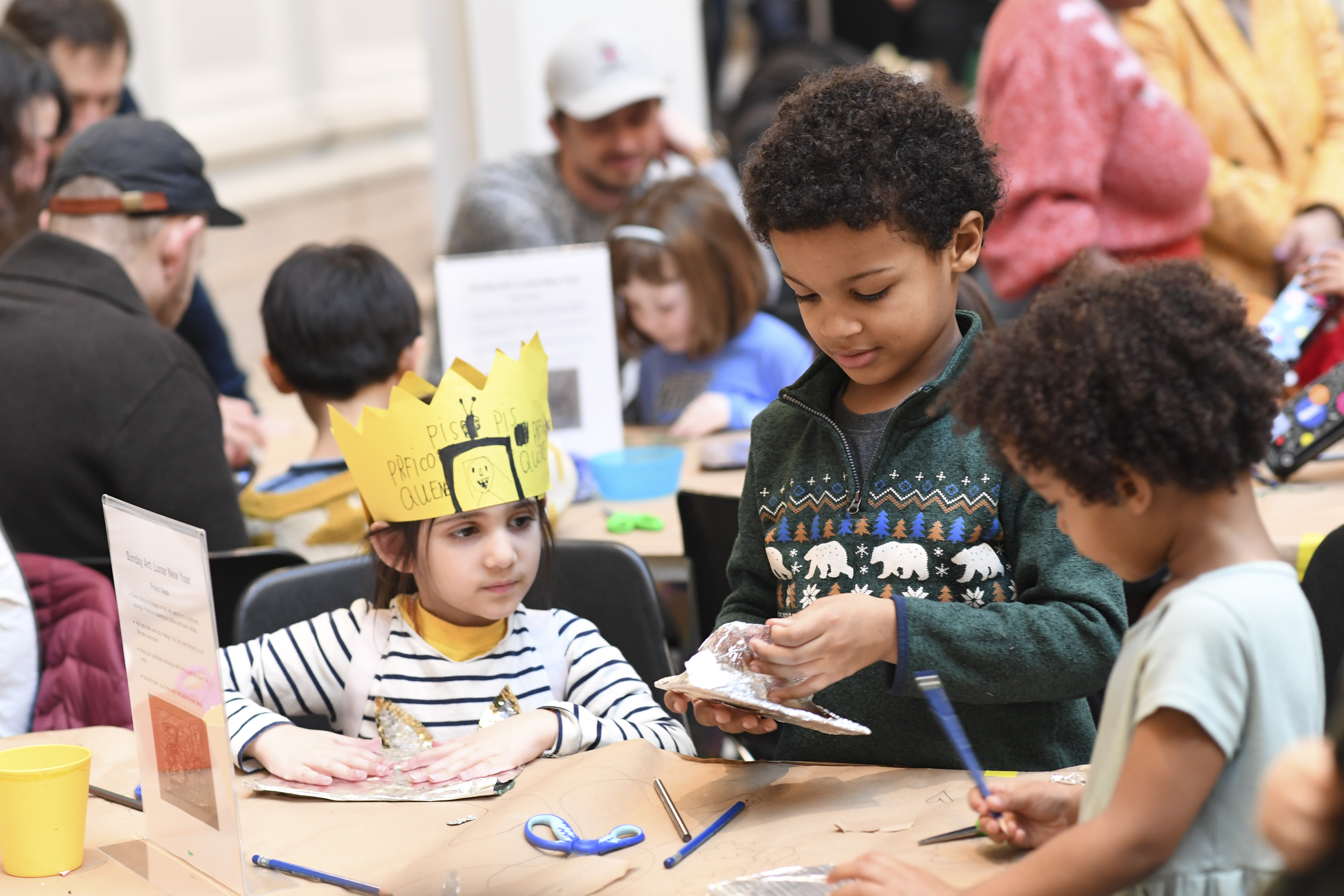 Kids making art, one wearing a crown