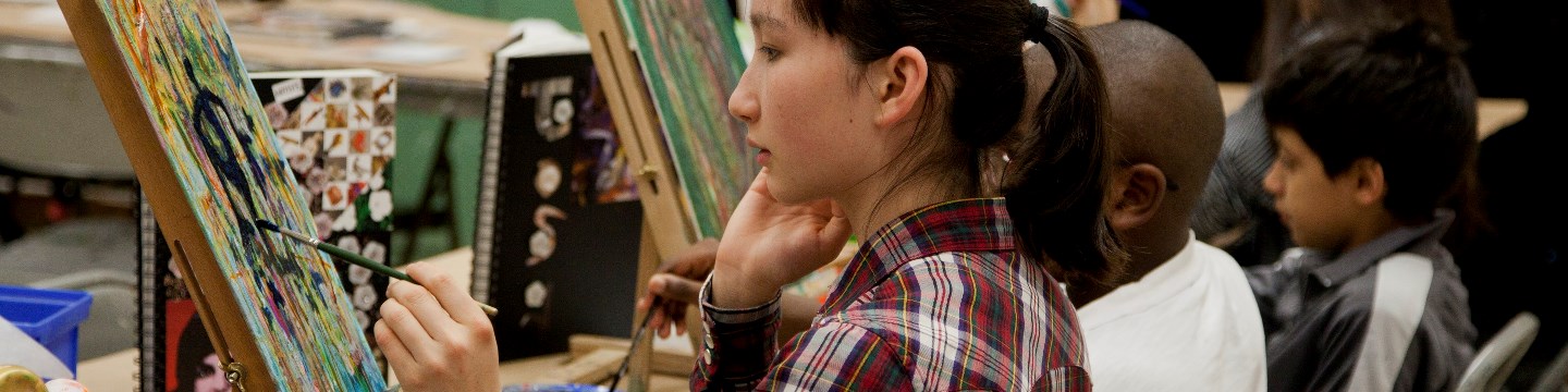 A teen paints in a Gallery/Studio art class