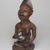 Yombe artist. <em>Figure of Mother and Child (Phemba)</em>, 19th century. Wood, glass, upholstery studs, metal, metal and glass buttons, resin, 11 x 5 x 4 1/2 in. (27.9 x 12.7 x 11.4 cm). Brooklyn Museum, Museum Expedition 1922, Robert B. Woodward Memorial Fund, 22.1138. Creative Commons-BY (Photo: , 22.1138_threequarter_left_PS9.jpg)