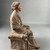  <em>Seated Figure of Woman with Fillet, Tanagra Style</em>. Terracotta, pigment, 6 1/2 × 3 9/16 × 4 1/8 in. (16.5 × 9 × 10.5 cm). Brooklyn Museum, Brooklyn Museum Collection, X249.75. Creative Commons-BY (Photo: Brooklyn Museum, CUR.X249.75_view02.jpeg)