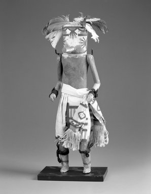 A:shiwi (Zuni Pueblo). <em>Kachina Doll (Kan-nachu)</em>, late 19th century. Wood,pigment, textile, yarn, string, feathers, 15 13/16 x 4 1/2 x 3 11/16 in. (40.2 x 11.4 x 9.4 cm). Brooklyn Museum, Museum Expedition 1907, Museum Collection Fund, 07.467.8437. Creative Commons-BY (Photo: Brooklyn Museum, 07.467.8437_bw.jpg)