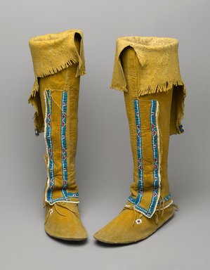 Osage, Comanche. <em>Pair of Women's Moccasins Attached to Leggings</em>, early 20th century. Hide, pigment, glass beads, sinew, fur, 24 1/2 x 3 1/4 x 9 1/2 in. (62.2 x 8.3 x 24.1 cm). Brooklyn Museum, Museum Expedition 1911, Museum Collection Fund, 11.694.9055a-b. Creative Commons-BY (Photo: Brooklyn Museum, 11.694.9055a-b_PS2.jpg)