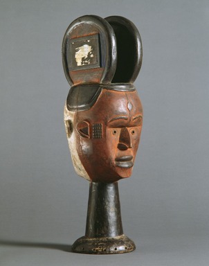 Nupe. <em>Janus-faced Dance Crest for Ekeleke Performance</em>, 20th century. Wood, glass mirror, pigment, 21 1/2 x 8 1/2 x 8 in. (54.6 x 21.6 x 20.3 cm). Brooklyn Museum, Gift of Ruth E. Wilner, 1990.222.2. Creative Commons-BY (Photo: Brooklyn Museum, 1990.222.2_SL3.jpg)