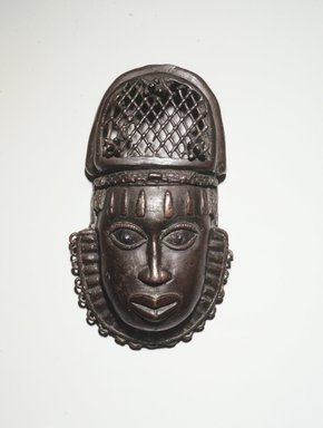 Edo. <em>Pendant Mask (Uhunmwu-Ẹkuẹ)</em>, 19th century. Copper alloy, iron, 7 3/4 × 4 5/16 × 1 3/4 in. (19.7 × 11 × 4.5 cm). Brooklyn Museum, Gift of Dorothy Robbins, 1993.180.15. Creative Commons-BY (Photo: Brooklyn Museum, 1993.180.15_transp5318.jpg)