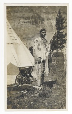 Unknown. <em>[Untitled] (Chief Standing in front of Teepee with Seated Woman)</em>, ca. 1900. Gelatin silver print, 5 1/4 x 3 1/8 in. (13.3 x 8.0 cm). Brooklyn Museum, Gift of Sasha Nyary and Family, 1997.163.5 (Photo: Brooklyn Museum, 1997.163.5_PS2.jpg)