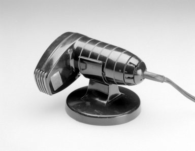 A.C. Gilbert Company. <em>Hair Dryer and Stand</em>, Patented June 6, 1944. Plastic, metal, (a) Hairdryer: 5 3/4 x 2 1/2 x 4 3/8 in. (14.6 x 6.4 x 11.1 cm). Brooklyn Museum, Gift of M. Christmann Zulli in honor of Robert Kaye, 2000.52a-b. Creative Commons-BY (Photo: Brooklyn Museum, 2000.52a-b_bw.jpg)