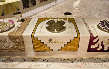 Judy Chicago (American, born 1939). <em>Ishtar Place Setting</em>, 1974-1979. Runner:Cotton/linen base fabric, woven interface support material (horsehair, wool, and linen), cotton twill tape, silk, synthetic gold cord, silk satin, flannel, felt, soutache, silk thread
Plate:Porcelain with overglaze enamel (China paint), metallic glaze, rainbow luster, Runner:51 1/4 x 29 3/4 in. (130.2 x 75.6 cm). Brooklyn Museum, Gift of The Elizabeth A. Sackler Foundation, 2002.10-PS-3. © artist or artist's estate (Photo: , 2002.10-PS-03_Ishtar_Jook_Leung_photo_9288r2.jpg)