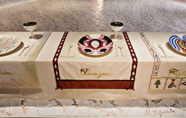 Judy Chicago (American, born 1939). <em>Amazon Place Setting</em>, 1974-1979. Runner: Cotton/linen base fabric, woven interface support material (horsehair, wool, and linen), cotton twill tape, silk, synthetic gold cord, snake skin, silk, linen, titanium, satin thread, cotton floss, thread
Plate:Porcelain with overglaze enamel (China paint), silver metallic glaze, gold metallic glaze, and rainbow luster, Runner:52 5/8 x 31 3/4 in. (133.7 x 80.6 cm). Brooklyn Museum, Gift of The Elizabeth A. Sackler Foundation, 2002.10-PS-7. © artist or artist's estate (Photo: , 2002.10-PS-07_Amazon_Jook_Leung_photo_9296r2.jpg)