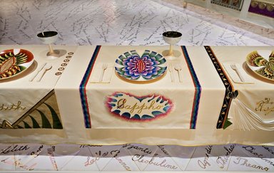 Judy Chicago (American, born 1939). <em>Sappho Place Setting</em>, 1974-1979. Runner:Cotton/linen base fabric, woven interface support material (horsehair, wool, and linen), cotton twill tape, silk, synthetic gold cord, padded silk satin fabric, silk thread
Plate: Porcelain with overglaze enamel (China paint), Runner:51 1/4 x 29 3/4 in. (130.2 x 75.6 cm). Brooklyn Museum, Gift of The Elizabeth A. Sackler Foundation, 2002.10-PS-10. © artist or artist's estate (Photo: , 2002.10-PS-10_Sappho_Jook_Leung_photo_9302r2.jpg)