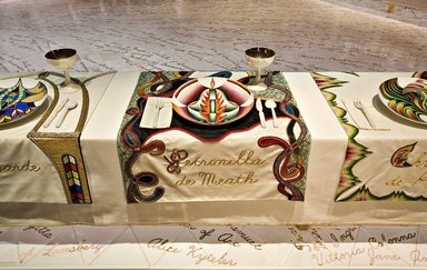 Judy Chicago (American, born 1939). <em>Petronilla de Meath Place Setting</em>, 1974-1979. Runner: Cotton/linen base fabric, woven interface support material (horsehair, wool, and linen), cotton twill tape, silk, synthetic gold cord, wool, silk, cotton, felt padding, wool and cotton cords, yarn, cotton floss, thread
Plate: Porcelain with overglaze enamel (China paint) and paint, Runner: 51 1/2 x 21 in. (130.8 x 53.3 cm). Brooklyn Museum, Gift of The Elizabeth A. Sackler Foundation, 2002.10-PS-21. © artist or artist's estate (Photo: , 2002.10-PS-21_Petronilla_de_Meath_Jook_Leung_photo_9334r2.jpg)