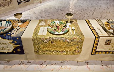 Judy Chicago (American, born 1939). <em>Mary Wollstonecraft Place Setting</em>, 1974-1979. Runner: Silk satin, cotton/linen base fabric, woven interface support material (horsehair, wool, and linen), cotton twill tape, silk, synthetic gold cord, felt padding, braid, buttons, lace, kid leather, ribbons, feathers, suede leather, silk, paint, silk thread
Plate: Porcelain with overglaze enamel (China paint), Runner: 52 1/2 x 30 3/4 in. (133.4 x 78.1 cm). Brooklyn Museum, Gift of The Elizabeth A. Sackler Foundation, 2002.10-PS-30. © artist or artist's estate (Photo: , 2002.10-PS-30_Mary_Wollstonecraft_Jook_Leung_photo_9361r2.jpg)