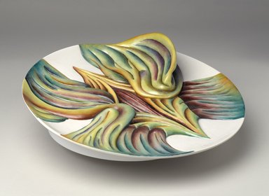 Judy Chicago (American, born 1939). <em>Mary Wollstonecraft Place Setting</em>, 1974-1979. Runner: Silk satin, cotton/linen base fabric, woven interface support material (horsehair, wool, and linen), cotton twill tape, silk, synthetic gold cord, felt padding, braid, buttons, lace, kid leather, ribbons, feathers, suede leather, silk, paint, silk thread
Plate: Porcelain with overglaze enamel (China paint), Runner: 52 1/2 x 30 3/4 in. (133.4 x 78.1 cm). Brooklyn Museum, Gift of The Elizabeth A. Sackler Foundation, 2002.10-PS-30. © artist or artist's estate (Photo: Brooklyn Museum, 2002.10-PS-30_threequarter_PS9.jpg)