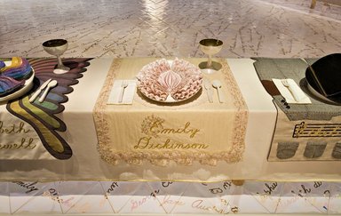 Judy Chicago (American, born 1939). <em>Emily Dickinson Place Setting</em>, 1974-1979. Runner: Cotton/linen base fabric, woven interface support material (horsehair, wool, and linen), cotton twill tape, silk, synthetic gold cord, silk fabric, cotton net, lace, appliquéd needlelace mid-19th-century collar, silk ribbon, coffee dye, tea dye, thread
Plate: Porcelain (or possibly stoneware), overglaze enamel (China paint), and possible additional paint, Runner: 54 x 33 1/2 in. (137.2 x 85.1 cm). Brooklyn Museum, Gift of The Elizabeth A. Sackler Foundation, 2002.10-PS-34. © artist or artist's estate (Photo: , 2002.10-PS-34_Emily_Dickinson_Jook_Leung_photo_9369r2.jpg)