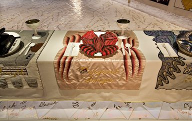 Judy Chicago (American, born 1939). <em>Margaret Sanger Place Setting</em>, 1974-1979. Runner: Silk satin, cotton/linen base fabric, woven interface support material (horsehair, wool, and linen), cotton twill tape, silk, synthetic gold cord, silk thread
Plate: Porcelain (possibly stoneware), overglaze enamel (China paint), paint, Runner: 51 1/4 x 31 7/8 in. (130.2 x 81 cm). Brooklyn Museum, Gift of The Elizabeth A. Sackler Foundation, 2002.10-PS-36. © artist or artist's estate (Photo: , 2002.10-PS-36_Margaret_Sanger_Jook_Leung_photo_9373r2.jpg)