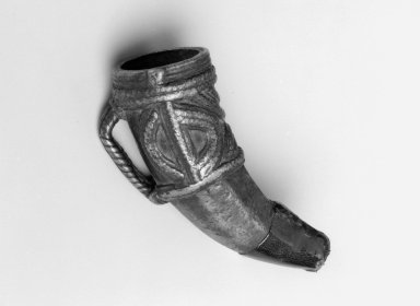 Possibly Dan. <em>Pendant in the Form of a Cow or Buffalo Horn</em>, 19th century. Copper alloy, leather
, 4 1/2 x 2 x 2 7/8 in. (11.4 x 5.1 x 7.3 cm). Brooklyn Museum, Gift of Blake Robinson, 2004.52.4. Creative Commons-BY (Photo: Brooklyn Museum, 2004.52.4_bw.jpg)
