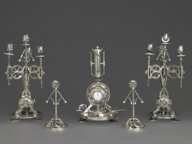 Andre´ Romain Guilmet (1827–1892). <em>Candlestick, Part of a Five Piece Clock Garniture</em>, ca. 1880. Nickel-plated metal, 9 1/4 x 4 1/2 x 4 1/2 in. (23.5 x 11.4 x 11.4 cm). Brooklyn Museum, Gift of Marcus S. Friedlander, by exchange, 2009.49.4. Creative Commons-BY (Photo: , 2009.49.1-.5_PS6.jpg)