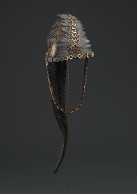 Lega. <em>Bwami Hat for Ngandu or Yananio Level</em>, late 19th or early 20th century. Plant fiber, mollusk shells, cowrie shells, buttons, pangolin scales, and pangolin tail
, 24 x 8 in. (61.0 x 20.3 cm). Brooklyn Museum, Designated Purchase Fund, 2011.3.2. Creative Commons-BY (Photo: Brooklyn Museum, 2011.3.2_front_PS6.jpg)