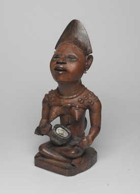 Yombe artist. <em>Figure of Mother and Child (Phemba)</em>, 19th century. Wood, glass, upholstery studs, metal, metal and glass buttons, resin, 11 x 5 x 4 1/2 in. (27.9 x 12.7 x 11.4 cm). Brooklyn Museum, Museum Expedition 1922, Robert B. Woodward Memorial Fund, 22.1138. Creative Commons-BY (Photo: , 22.1138_threequarter_left_PS9.jpg)