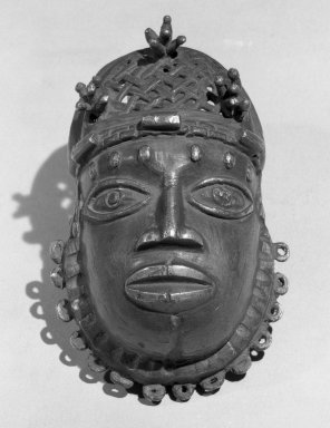 Edo. <em>Pendant Mask (Uhunmwu-Ẹkuẹ)</em>, 19th century. Copper alloy, 4 15/16 × 2 15/16 in. (12.5 × 7.5 cm). Brooklyn Museum, Museum Expedition 1923, Purchased with funds given by Frederic B. Pratt and Frank L. Babbott, 23.280. Creative Commons-BY (Photo: Brooklyn Museum, 23.280_acetate_bw.jpg)