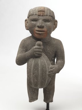 Aztec. <em>Man Carrying a Cacao Pod</em>, 1440-1521. Volcanic stone, traces of red pigment, 14 1/4 x 7 x 7 1/2in. (36.2 x 17.8 x 19.1cm). Brooklyn Museum, Museum Collection Fund, 40.16. Creative Commons-BY (Photo: Brooklyn Museum, 40.16_front_PS9.jpg)