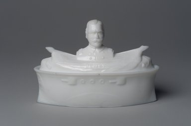 American. <em>Covered Dish, Battleship with Admiral George Dewey</em>, 1899. Glass, 4 1/4 x 6 5/8 x 3 in. (10.8 x 16.8 x 7.6 cm). Brooklyn Museum, Gift of Mrs. William Greig Walker by subscription, 40.260a-b. Creative Commons-BY (Photo: Brooklyn Museum, 40.260a-b.jpg)