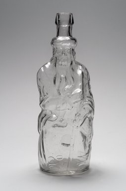 American. <em>Bottle, Figure of Seated Old Man</em>, 19th century. Glass, 11 3/8 x 4 1/4 x 4 1/8 in. (28.9 x 10.8 x 10.5 cm). Brooklyn Museum, Gift of Mrs. V. B. Howe, 40.378. Creative Commons-BY (Photo: Brooklyn Museum, 40.378.jpg)
