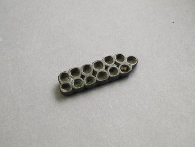 Akan. <em>Gold-weight (abrammuo): mancala board</em>, late 19th-mid 20th century. Bronze, 11/16 x 2 1/4 in. (1.7 x 5.7 cm). Brooklyn Museum, A. Augustus Healy Fund, 44.231.28. Creative Commons-BY (Photo: Brooklyn Museum, 44.231.28_PS5.jpg)