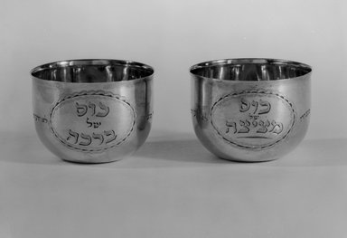 Hester Bateman (English, active in London, 1774–1789). <em>Jewish Ceremonial Wine Cup, One of Pair</em>, 1785–1786 with late 19th–century inscriptions. Silver, 1 3/4 x 2 7/16 x 2 7/16 in. (4.4 x 6.2 x 6.2 cm). Brooklyn Museum, Ella C. Woodward Memorial Fund, 51.110.1. Creative Commons-BY (Photo: , 51.110.1_51.110.2_bw.jpg)