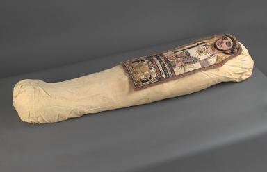  <em>Cartonnage and Mummy of an Anonymous Man</em>, 3rd century C.E. Human remains, wood (Ficus sycomorus, sycomore fig), grass, linen, plaster, pigment, a: cartonnage: 13 1/4 x 35 7/16 in. (33.7 x 90.0 cm). Brooklyn Museum, Charles Edwin Wilbour Fund, 52.128a-e. Creative Commons-BY (Photo: Brooklyn Museum, 52.128a_52.128e_PS2.jpg)