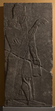 Assyrian. <em>Apkallu-figure with Armlets</em>, ca. 883-859 B.C.E. Gypsum stone, pigment, 89 3/8 x 42 1/8 in. (227 x 107 cm). Brooklyn Museum, Purchased with funds given by Hagop Kevorkian and the Kevorkian Foundation, 55.145. Creative Commons-BY (Photo: Brooklyn Museum, 55.145_at_PS11.jpg)