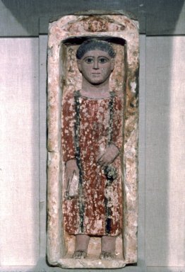 Coptic. <em>Funerary Stela with Boy Standing in a Niche</em>, 4th-5th century C.E. Limestone, ancient and modern paint in ochre, dark terracotta, brown, black and flesh-tone, 27 9/16 x 9 5/8 x 6 1/2 in. (70 x 24.5 x 16.5 cm). Brooklyn Museum, Charles Edwin Wilbour Fund, 58.129. Creative Commons-BY (Photo: Brooklyn Museum, 58.129.jpg)