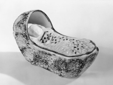 American. <em>Cradle with Child</em>, ca. 1760. Glazed earthenware, 2 1/2 x 2 x 4 1/2 in. (6.4 x 5.1 x 11.4 cm). Brooklyn Museum, Gift of the Monroe and Estelle Hewlett Collection, 67.124.7. Creative Commons-BY (Photo: Brooklyn Museum, 67.124.7_bw.jpg)