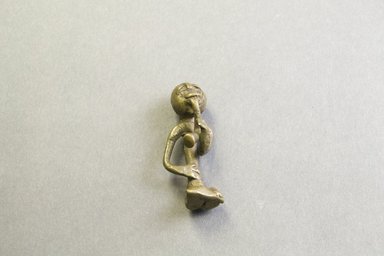 Akan. <em>Gold-weight (abrammuo): seated figure</em>. Brass, 2 3/8 x 1 x 13/16 in. (6 x 2.5 x 2 cm). Brooklyn Museum, Bequest of Laura L. Barnes, 67.25.2. Creative Commons-BY (Photo: Brooklyn Museum, 67.25.2_PS5.jpg)