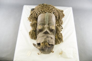  <em>Mask</em>, late 19th–early 20th century. Wood, ivory tusks, copper, fur, hide, cowrie shells, 14 1/2 in.  (36.8 cm). Brooklyn Museum, Gift of Jerome Furman, 70.151.5. Creative Commons-BY (Photo: Brooklyn Museum, 70.151.5_front_PS5.jpg)