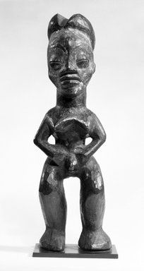 Lumbo. <em>Standing Figure with Legs Apart, Arms Akimbo and Hands Joined to Abdomen</em>, late 19th-early 20th century. Wood, 12 1/2 x 4 x 3 1/2 in. (31.7 x 10.2 x 9.0 cm). Brooklyn Museum, Gift of Mr. and Mrs. John A. Friede, 73.107.4. Creative Commons-BY (Photo: Brooklyn Museum, 73.107.4_bw.jpg)