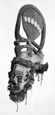 Nupe. <em>Maiden Spirit Helmet Mask (Agbogho Mmuo)</em>, early 20th century. Wood, pigment, cloth, fiber, 22 1/2 x 8 x 12 1/2 in. (57.2 x 20.3 x 31.8 cm). Brooklyn Museum, Gift of Mr. and Mrs. J. Gordon Douglas III, 74.211.2. Creative Commons-BY (Photo: Brooklyn Museum, 74.211.2_bw.jpg)