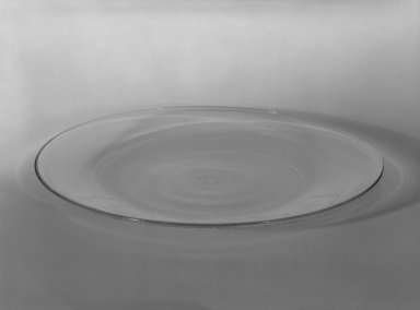 Wilhelm Wagenfeld (1900-1990). <em>Cake Plate</em>, 1930-1934. Clear heat-resistant glass, 9/16 x 7 7/8 in. (1.4 x 20 cm). Brooklyn Museum, Gift of Barry Friedman, 84.64.13. Creative Commons-BY (Photo: Brooklyn Museum, 84.64.13_bw.jpg)
