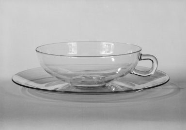 Wilhelm Wagenfeld (1900-1990). <em>Cup and Saucer</em>, 1930-1934. Clear heat-resistant glass, 1 3/8 x 5 1/8 x 3 7/8 in. (3.5 x 13 x 9.8 cm). Brooklyn Museum, Gift of Barry Friedman, 84.64.4a-b. Creative Commons-BY (Photo: Brooklyn Museum, 84.64.4a-b_bw.jpg)