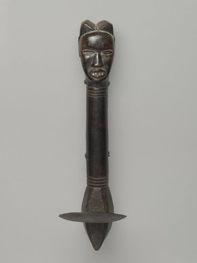 Feia Tomekpa (Dan, flourished 1940s-early 1950s). <em>Ceremonial Hoe</em>, 20th century. Wood, iron, 14 1/8 x 2 1/4 x 4 1/16 in. (35.9 x 5.7 x 10.3 cm). Brooklyn Museum, Gift of Mr. and Mrs. Brian S. Leyden, 87.216.1. Creative Commons-BY (Photo: Brooklyn Museum, 87.216.1_front_PS6.jpg)
