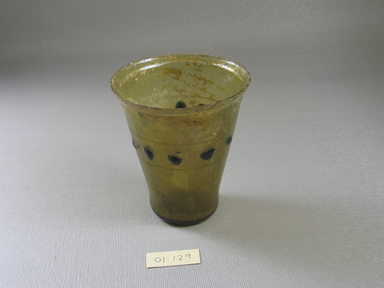 Roman. <em>Goblet with Blue Dots</em>, 4th-early 5th century C.E. Glass, 3 7/16 x greatest diam. 3 1/16 in. (8.8 x 7.7 cm) . Brooklyn Museum, Gift of Robert B. Woodward, 01.129. Creative Commons-BY (Photo: Brooklyn Museum, CUR.01.129.jpg)