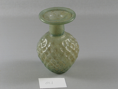 Roman. <em>Sprinkler Bottle with Molded Lozenge Pattern</em>, first half of 3rd century C.E. Glass, 3 5/8 x Diam. 2 1/2 in. (9.2 x 6.4 cm). Brooklyn Museum, Gift of Robert B. Woodward, 01.1. Creative Commons-BY (Photo: Brooklyn Museum, CUR.01.1_view1.jpg)