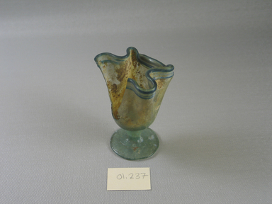 Islamic. <em>Handkerchief Form Cup</em>, 4th-9th century C.E. Glass, 3 3/16 x greatest diam. 2 5/8 in. (8.1 x 6.7 cm). Brooklyn Museum, Gift of Robert B. Woodward, 01.237. Creative Commons-BY (Photo: Brooklyn Museum, CUR.01.237_view1.jpg)