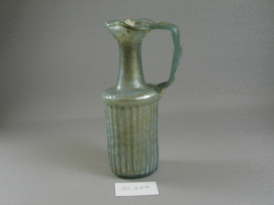 Roman. <em>Jug with Vertical Molded Decoration</em>, 4th century C.E. Glass, 6 11/16 x 2 11/16 x 3 3/4 in. (17 x 6.9 x 9.5 cm). Brooklyn Museum, Gift of Robert B. Woodward, 01.259. Creative Commons-BY (Photo: Brooklyn Museum, CUR.01.259_view1.jpg)